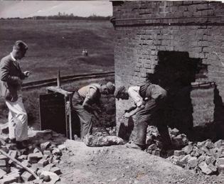 Archive photograph of workers cutting into the base of a chimney