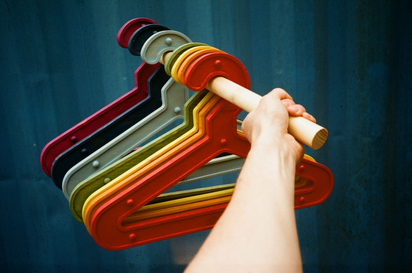 The full range of Girder Hangers hung in a rainbow on a wooden rail