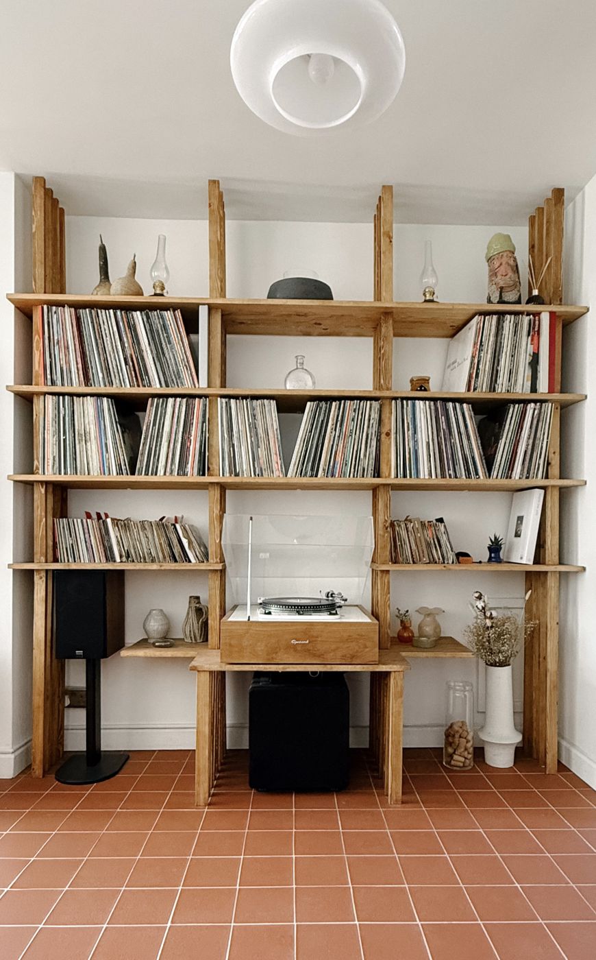The full bespoke shelving unit from the front, records and turntable above a terracotta tiled floor