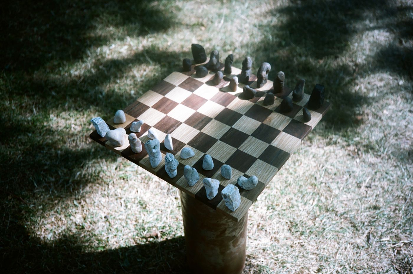 The set on its column from a corner, light falling across the board
